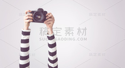 女性举起手臂，拿着相机，孤立的背景