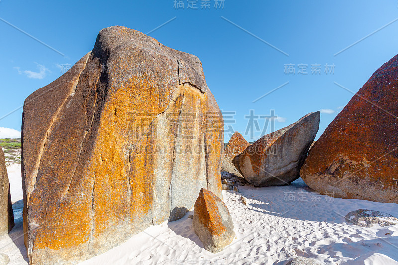 海边沙滩上有巨大的橙色岩石。吱吱海滩，威尔逊海角国家公园，澳大利亚