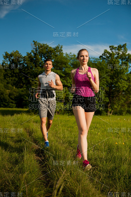 活跃的年轻夫妇在公园里跑步