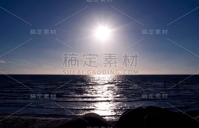 丹麦:从北日德兰半岛的一艘港口鼹鼠上俯瞰夕阳在海面上的倒影