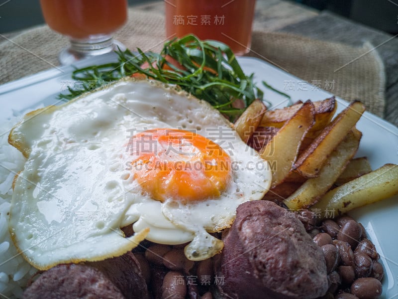 巴西食品菜肴。豆子，米饭，鸡蛋，沙拉和土豆。乡村木背景