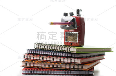 红色金属卷笔刀上五颜六色的书孤立