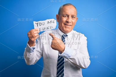资深帅商人捧着你被炒的纸，隔着孤立的蓝色背景很开心的指指点点