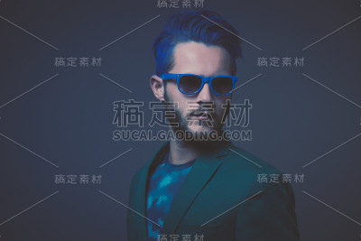 蓝色头发和棕色胡子的男人穿着绿色的衣服。