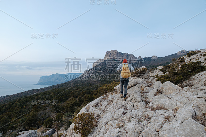 男人背包徒步旅行和红帽子在山区