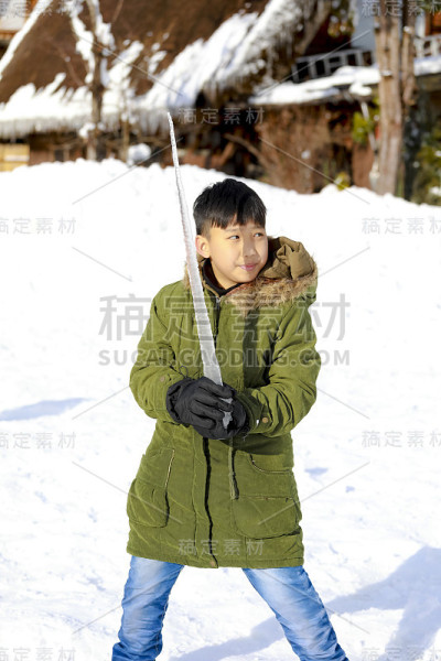冰剑在男孩手中，在雪地上享受冬天的雪