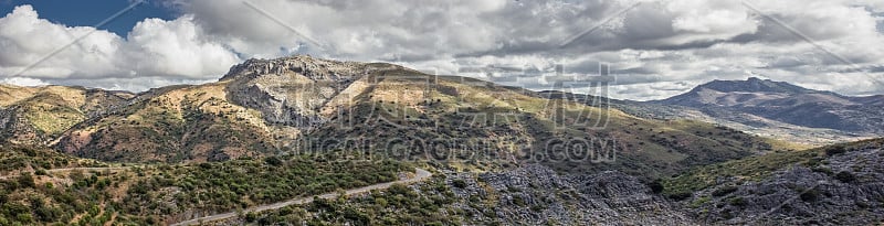 山景上的蓝色多云的天空背景。风景如画的群山在阳光下闪闪发光。令人屏息的自然影像