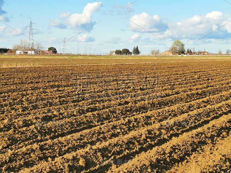 在为春季种植庄稼而犁过的农田上的垄沟。透视中的水平视图。