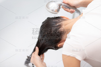 美丽和卫生。女孩在家里的浴室里用洗发水洗头。