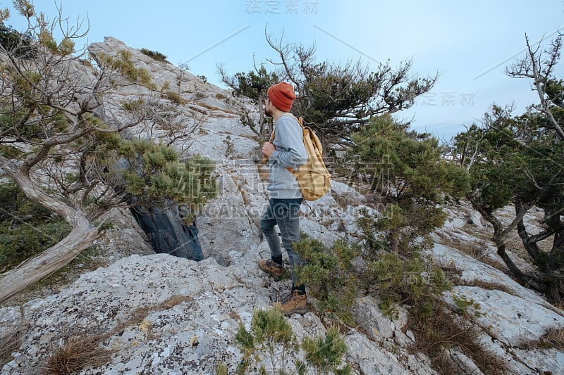 男人背包徒步旅行和红帽子在山区