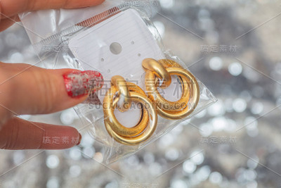 不对称的黄金耳环与分层的戒指