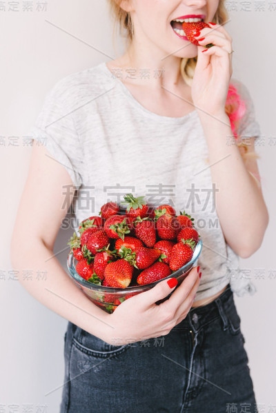 年轻迷人的快乐的女模特与草莓