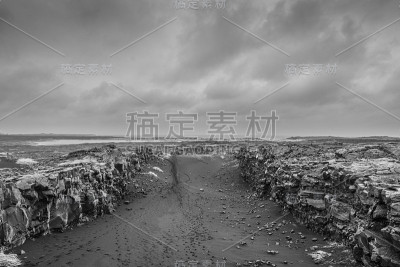 在冰岛大陆之间的桥梁黑色的沙子峡谷在暴风雨的天气在黑色和白色