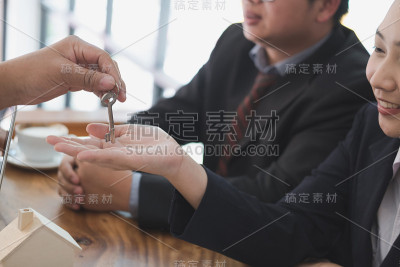 房地产经纪人与客户会面。出售和购买房产的房子模型和钥匙。房地产经纪人与客户交谈。