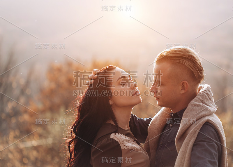 一对美丽的年轻夫妇在美丽的夕阳下散步。