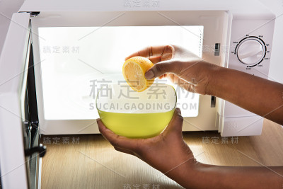 人手将柠檬片放入碗中