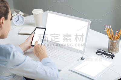 使用笔记本电脑和智能手机的女性