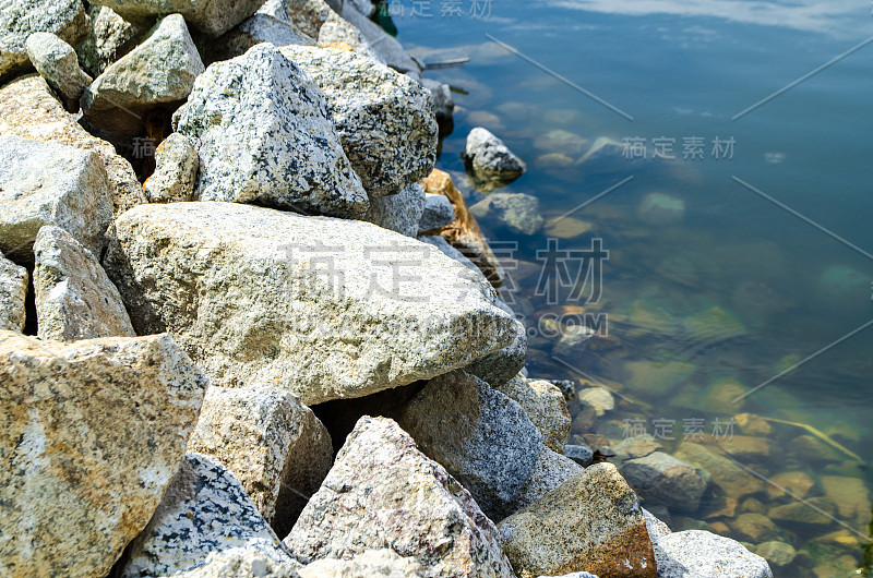 large stones on the shore of the sea on sunny day