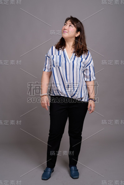 工作室拍摄的成熟美丽的亚洲女商人在灰色的背景