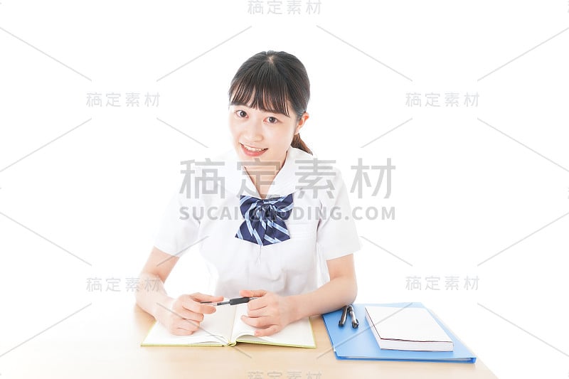 穿制服的年轻学生在书桌前学习