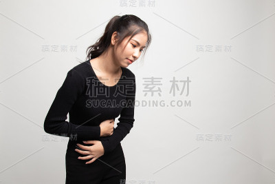 一位年轻的亚洲妇女胃痛。