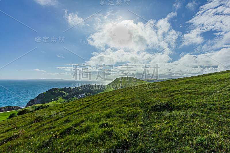 在壮丽的蓝天和白云下，沿着多塞特的侏罗纪海岸的卢沃斯湾山