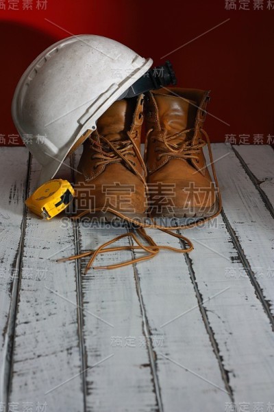 工作靴，白色建筑师头盔和米制胶带