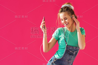 积极的女孩用耳机听音乐