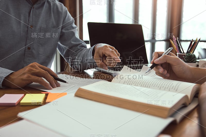 一个十几岁的学生在他的房间里做家庭作业，在笔记本上写东西。