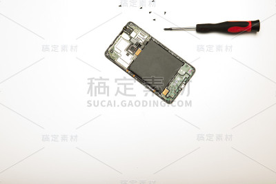 智能手机和精密螺丝刀和螺丝在白色之上
