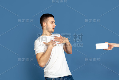 蓝色画室背景上的白人青年肖像