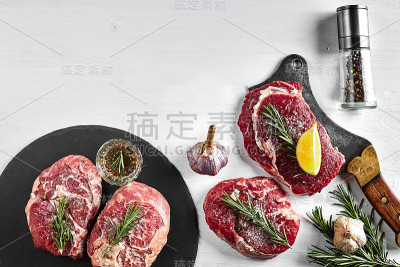 新鲜的生牛排配香草，大蒜，橄榄油，胡椒，盐和迷迭香在黑板上:里脊肉，Striploin，肋眼