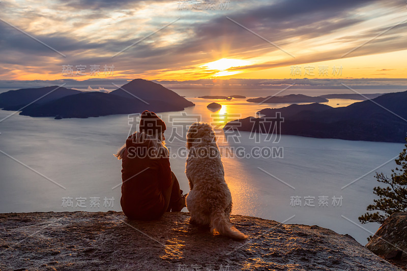 爱冒险的女孩带着狗在山顶徒步旅行