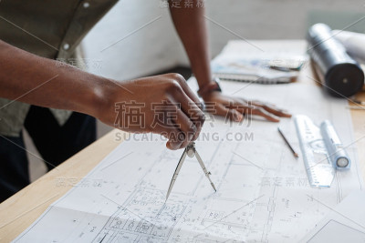 非裔美国建筑师在办公室里设计蓝图。工程师检查建筑平面图，为建筑工程画草图。黑人英俊男子坐在工作场所的