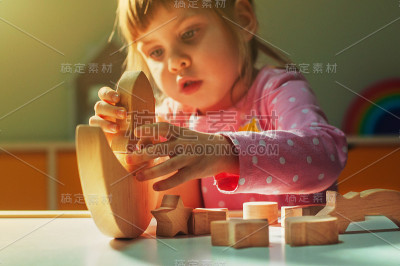 美丽的小女孩玩木制玩具银河平衡器