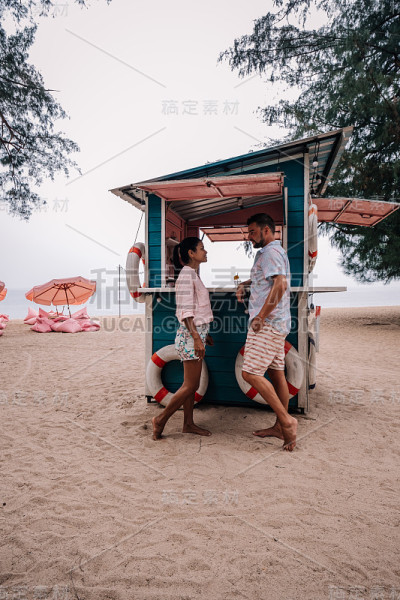 在泰国的芭堤雅，一对情侣在海滩上放松，海滩俱乐部和餐厅