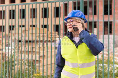 一位女建筑工在建筑工地检查建筑物