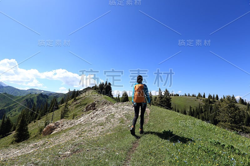 年轻女子徒步旅行在美丽的山峰