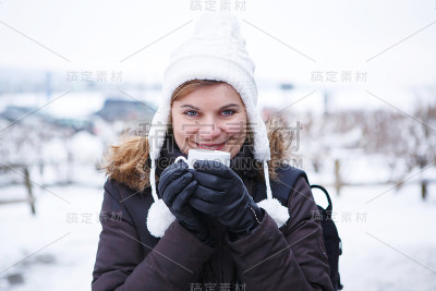 户外肖像年轻美丽的女人喝热咖啡