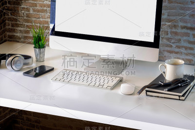 俯视图工作空间模型桌面电脑，咖啡杯和设计师的办公用品在白色的木材。