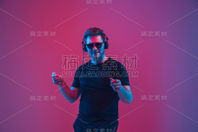 年轻的白人音乐家在霓虹灯下唱歌跳舞