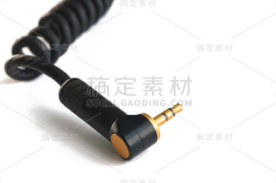 黑色音频仪器电缆与金色立体声3.5毫米插头隔离在白色特写
