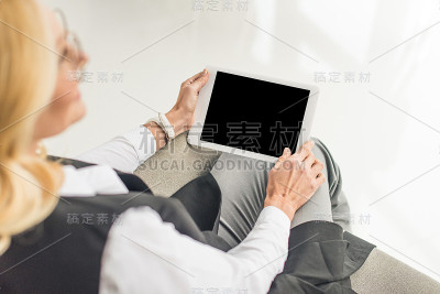 戴眼镜的女商人用数码平板电脑
