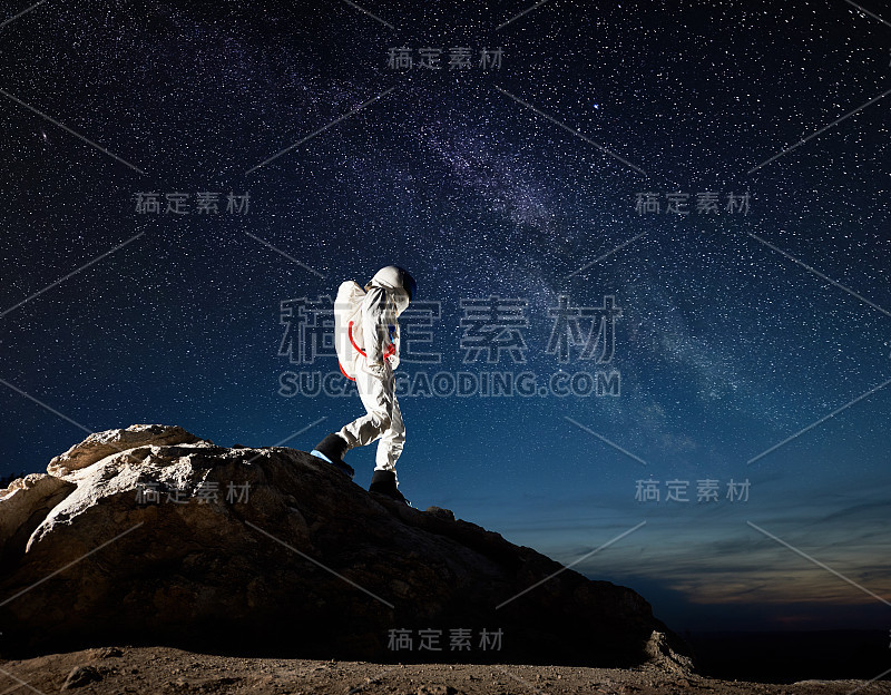 太空旅行者在星空下走下山。