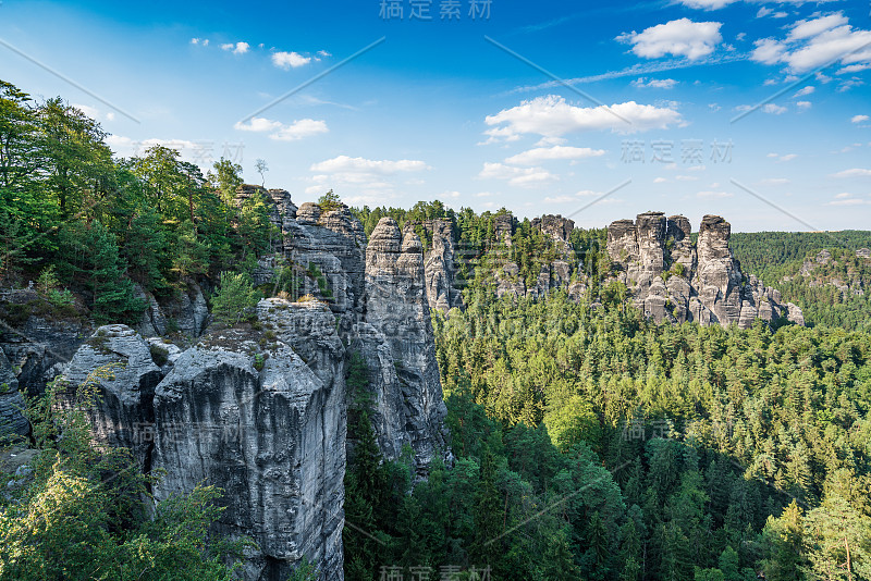 瑞士波西米亚的坏山道。巴斯蒂桥和山景。狭窄的岩石，天然的砂岩拱门在欧洲。有绿色植物、蓝天和阳光的山景