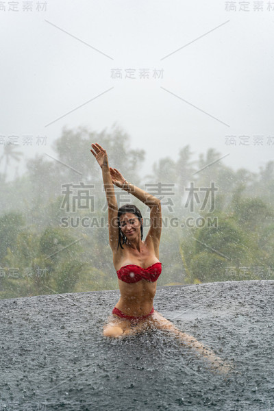 快乐苗条的黑发年轻女子坐在户外