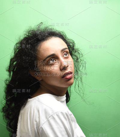 有着一头黑发的中东年轻女子。室内照片的奇妙女性模特在绿色的背景。