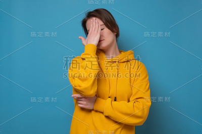 恼怒的成年女人捂着脸。