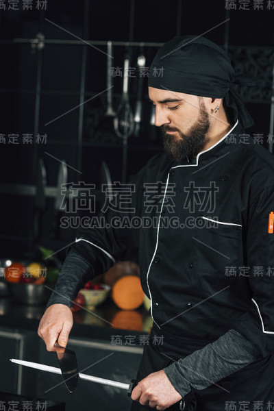 男厨师在厨房里磨刀