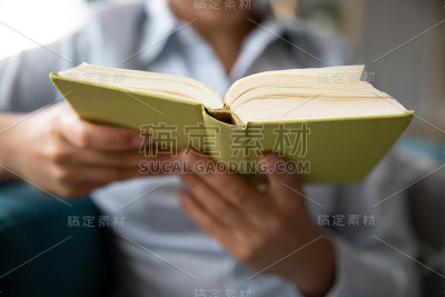 年轻女子坐在沙发上看书